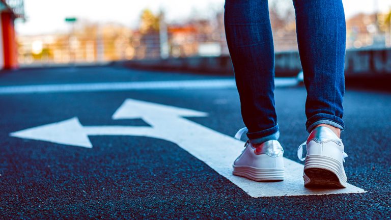 A coach walks on a multi-directional arrow.