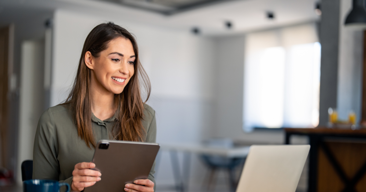 woman holding a tablet working on a website for her coaching business